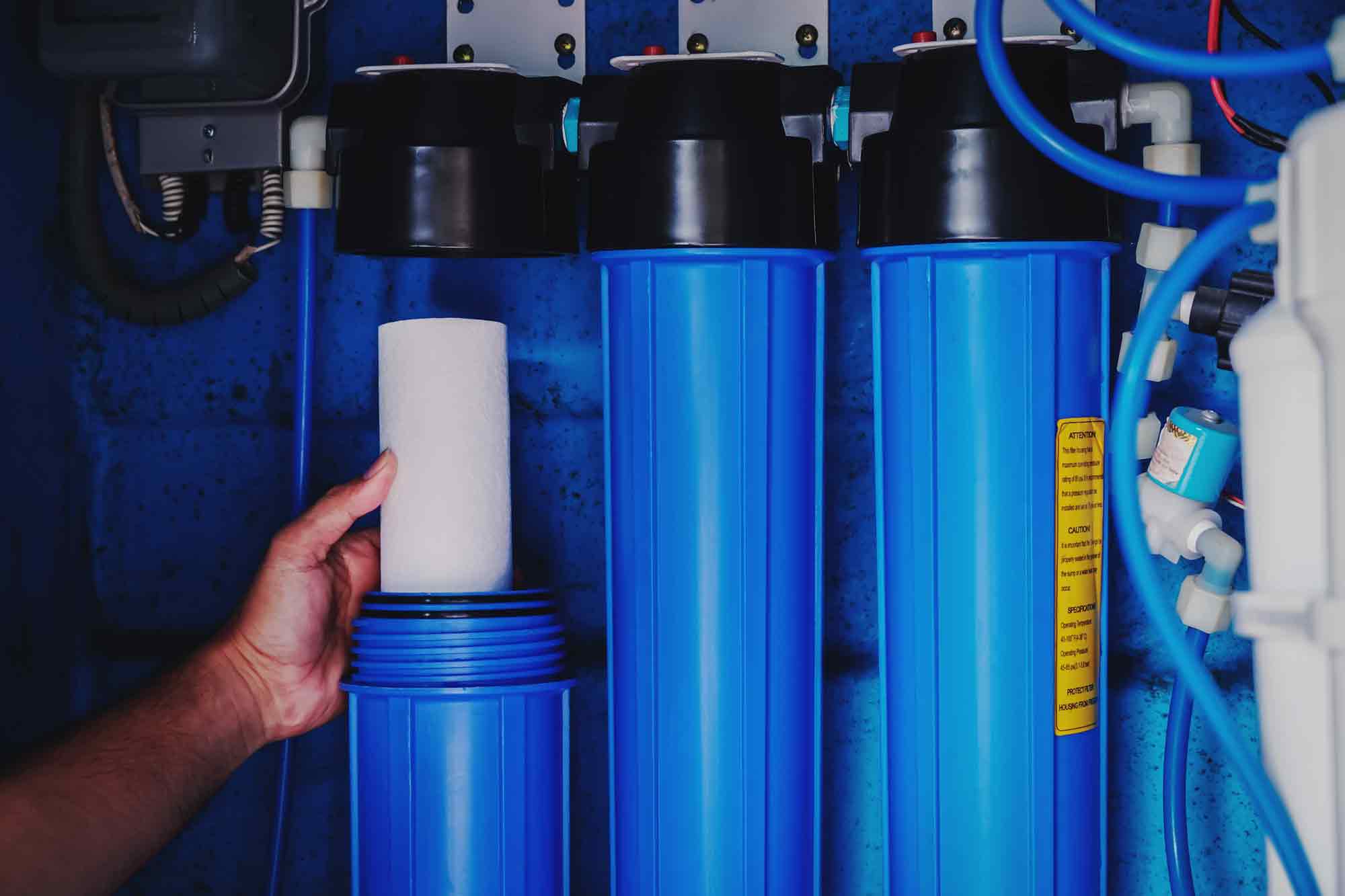 persona cambiando los filtros del descalcificador de agua 