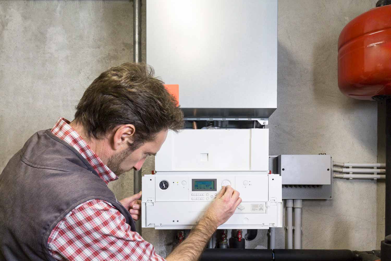Técnico revisando e instalando caldera de gas